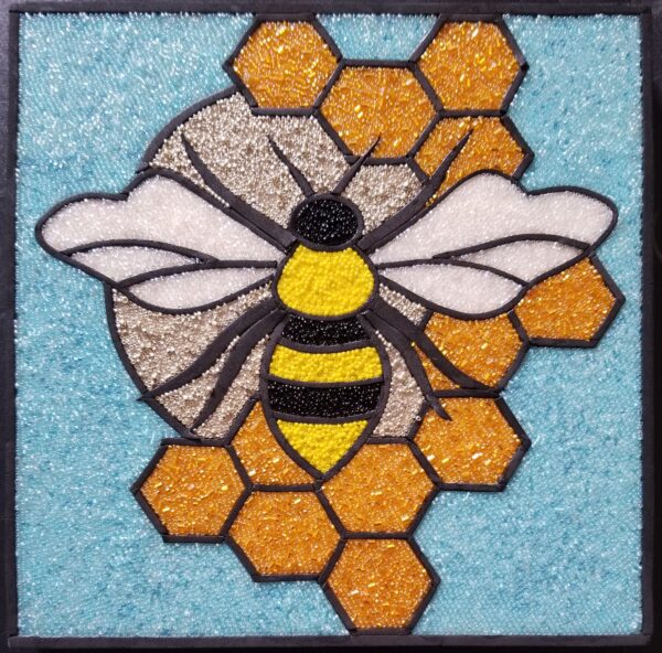 glass mosaic of a bee on a honeycomb
