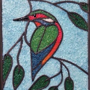 glass mosaic of a hummingbird resting on a tree