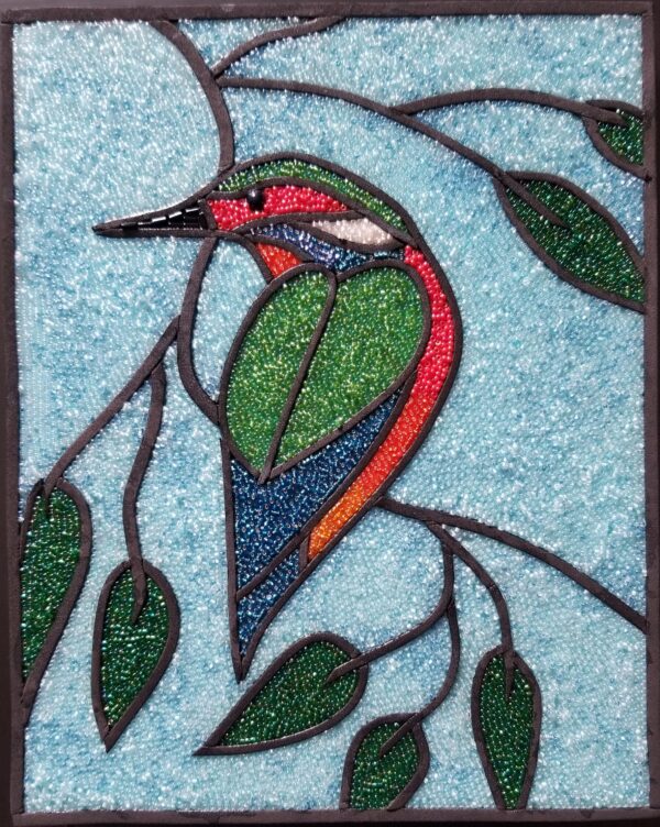 glass mosaic of a hummingbird resting on a tree